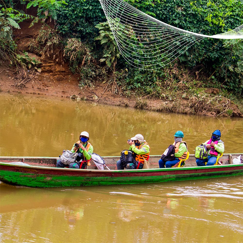 Equipo de investigadores navegando en canoa por río en área de influencia minera de Cerro Matoso durante monitoreo de biodiversidad, Montelíbano, Córdoba, Colombia.